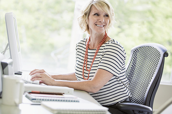 Female teacher typing on a desktop computer